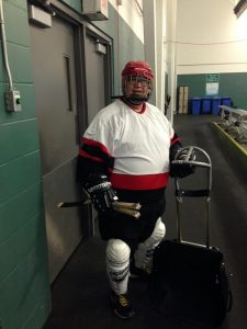Person dressed in hockey gear near a rink